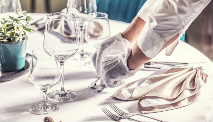 camarero preparando mesa en la sala de restaurante