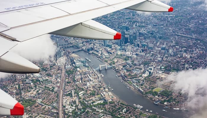 avion entre nubes sobre ciudad. viajes